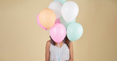 girl with several balloons floating